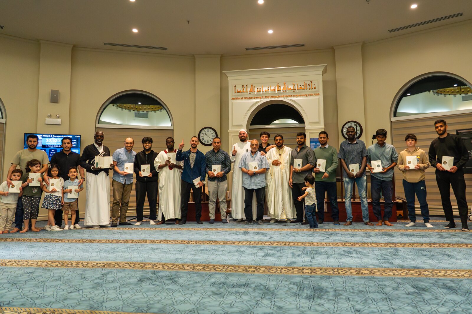 Children holding the copies of the Qur'an they received.