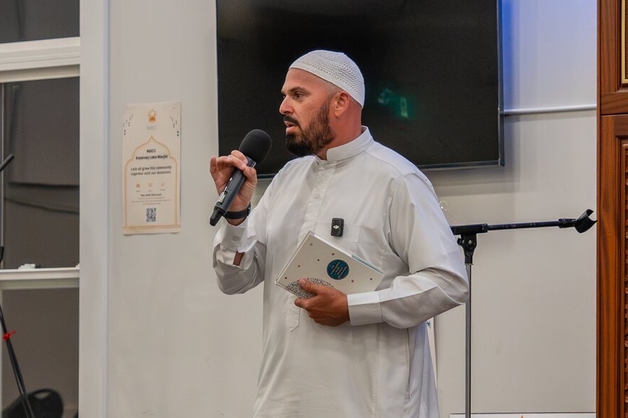 A Salik Foundation sheikh addressing the congregation beside the minbar.